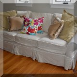F57. Slipcovered sofa. 28”h x 91”w x 36”d 